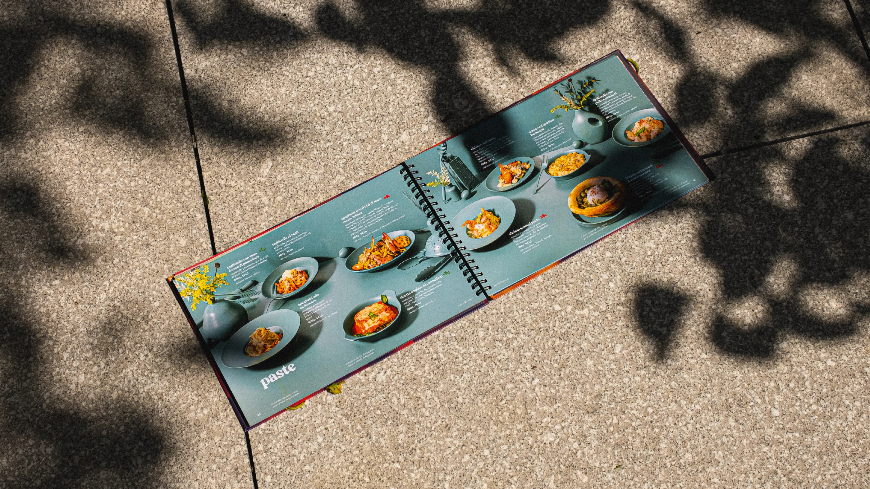 Open blue Marty Restaurants menu displaying plated dishes on pavement