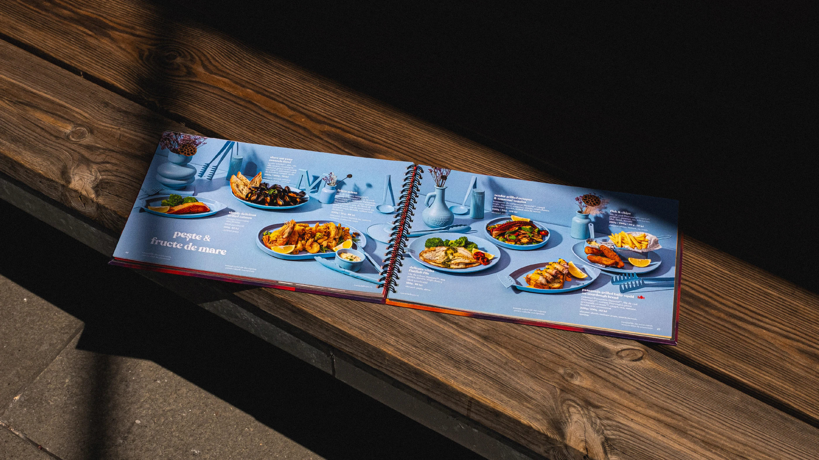 Open Marty Restaurants menu displaying plated dishes on a wooden bench
