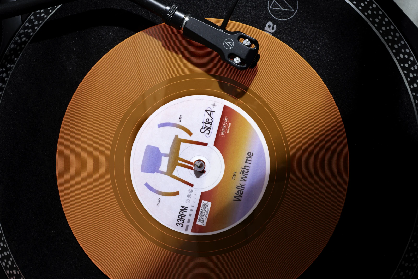 Close-up of the orange WALK WITH ME vinyl record