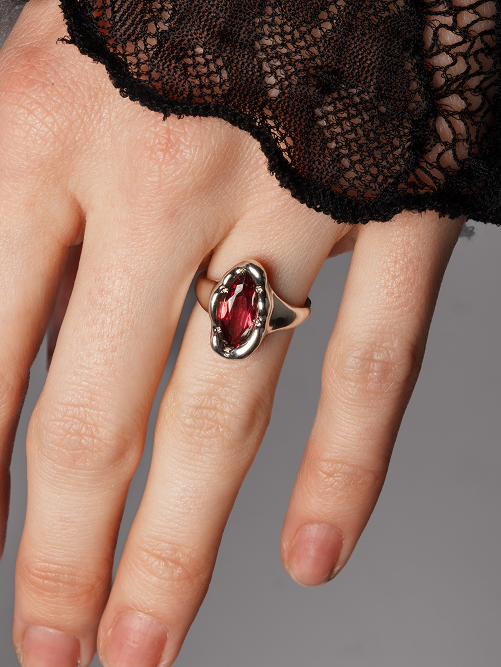 Hand wearing a Maier Jewelry ring with a red gemstone