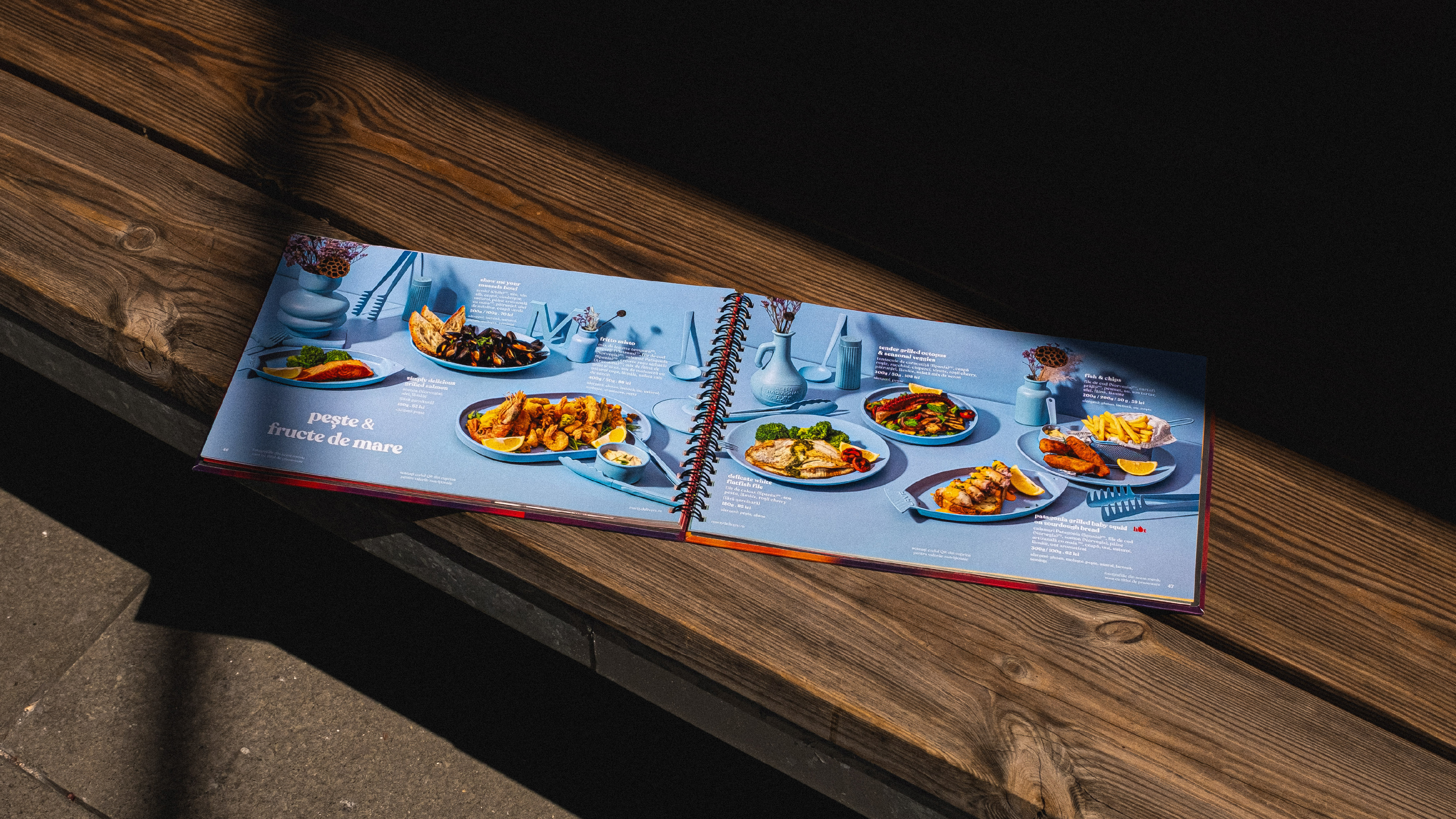 Open Marty Restaurants menu displaying plated dishes on a wooden bench